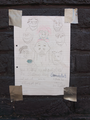 A drawn poster depicting many 'jaks, an advertisement for the sharty, 'ru, and the 'ki duct taped onto a coal brick wall. Ironically claiming to be "for everyone" and "non-bigoted" to bait people into using the sites.