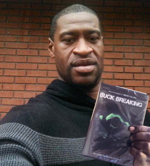 George Floyd holding a copy of Buck Breaking.png